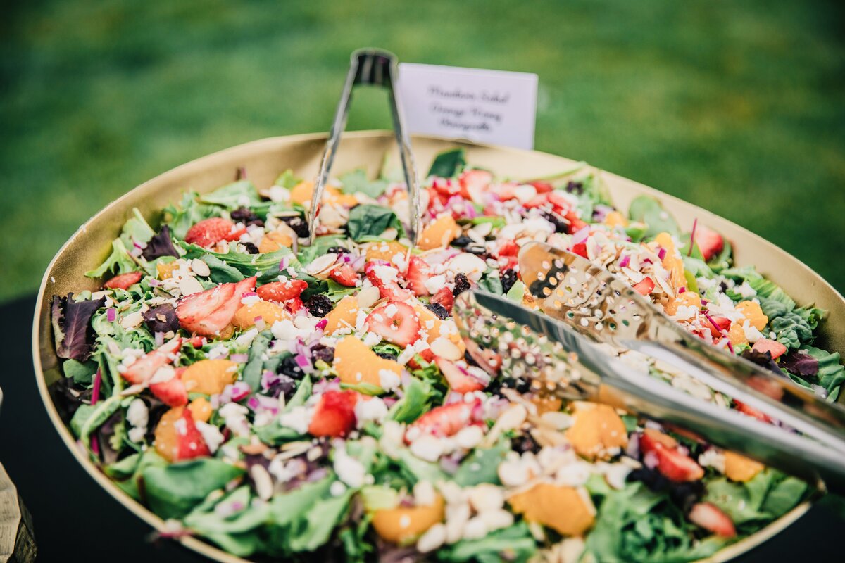 Chef plating and finishing dishes at a Savory Peaks catered event